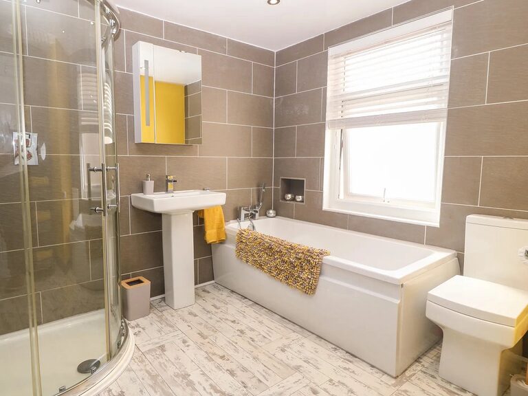 3-Bed Garden Apartment family bathroom with yellow feature wall, bath and separate shower