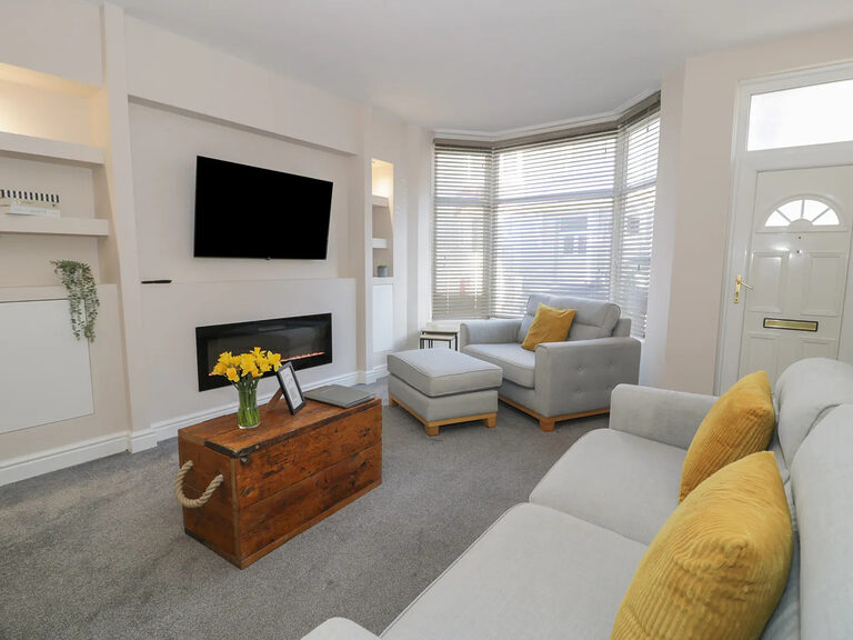 Townhouse sitting room with grey sofas and flame-effect electric fire