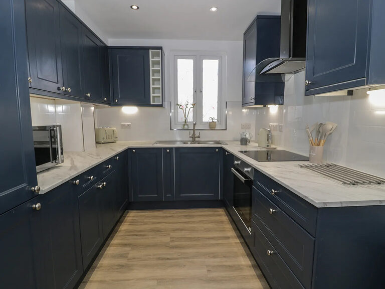 Navy shaker-style kitchen with marble-effect worktops in the Townhouse